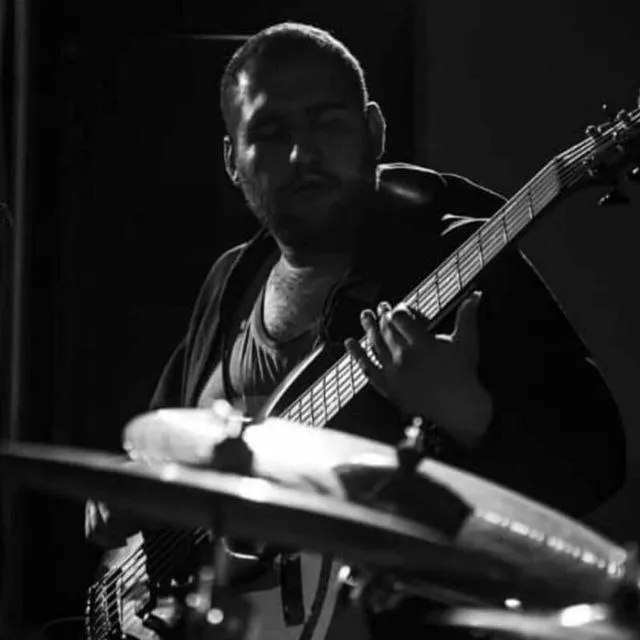 Eyes closed behind a cymbal, black and white