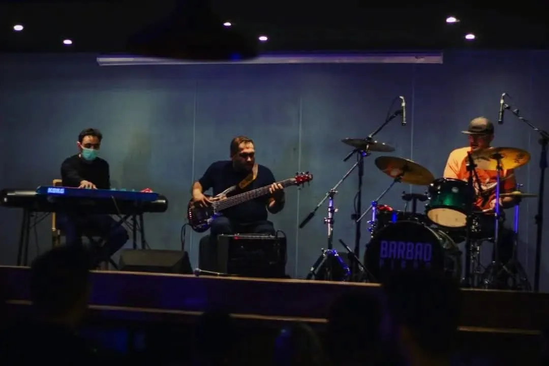 Club trio set on a blue-lit stage